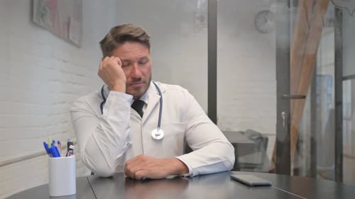 Mature Adult Doctor Sleeping in Clinic