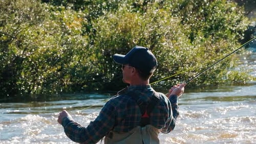 Man Fly Fishing in a Fast-Moving River