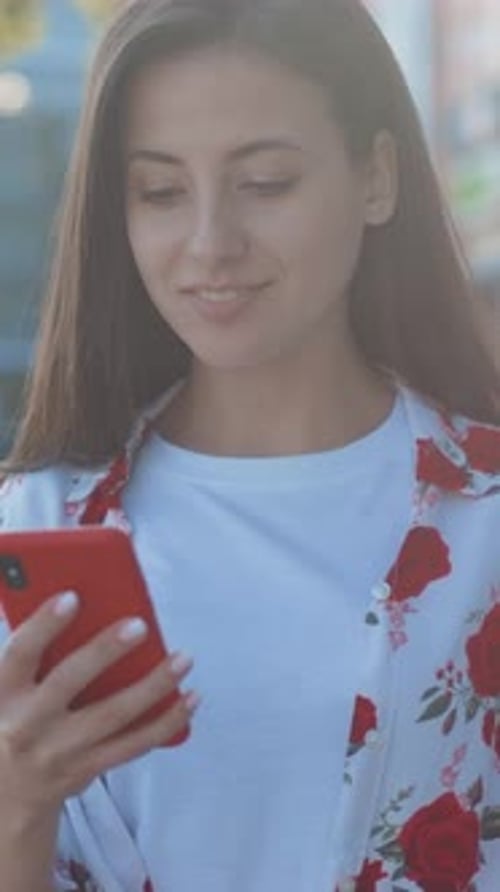 Smiling Woman Using Mobile Phone Outdoors