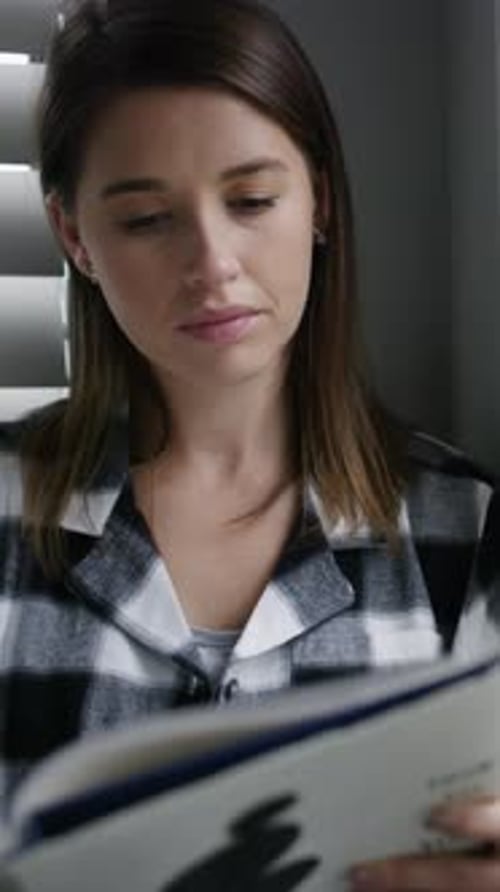 Young Woman Reading Book with Graphic Design Indoors
