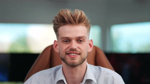Executive Confidence: Young Businessman Looks Directly at Camera in Modern Office, Close-Up Shot as