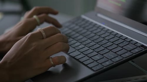 Female Programmer Typing Program Code and Working on Laptop in Office