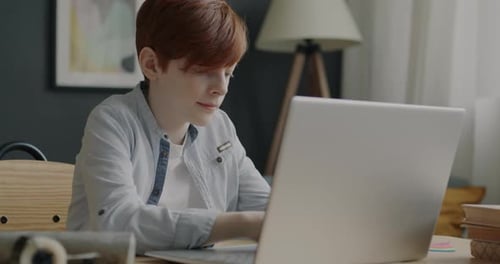 Teen Using Laptop at Home Desk