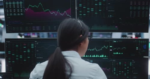 Female Broker Monitors Real Time Indices in Massive Digital Trading Room