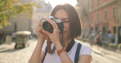 Woman Taking Picture with Vintage Camera in City