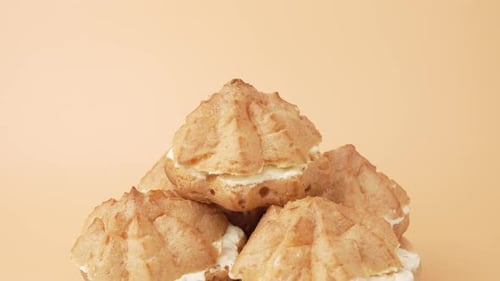 Close-up of Stacked Cream Puffs on Beige