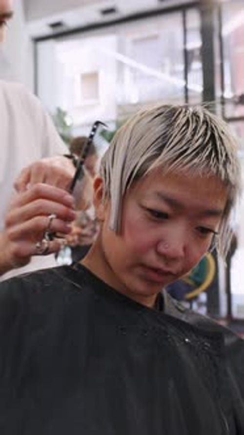 Stylist Cutting Woman's Short Hair in Salon