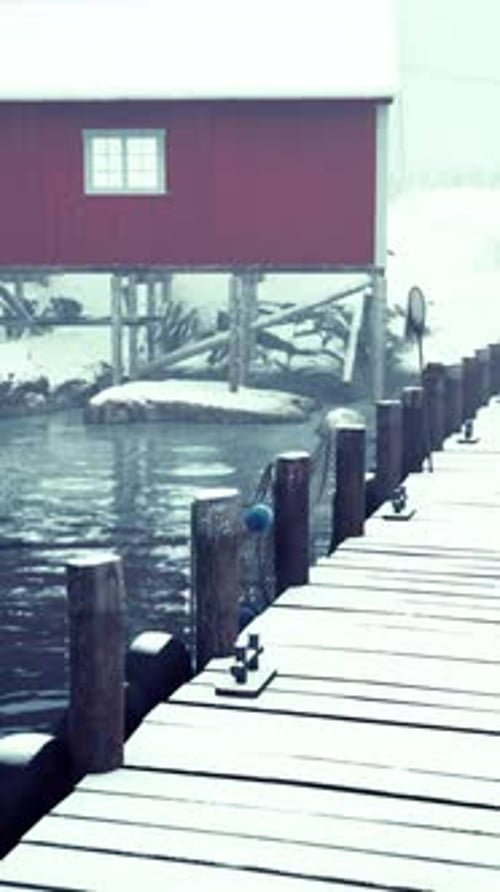 Old Wooden Pier With Red House on Cold Norwegian Sea