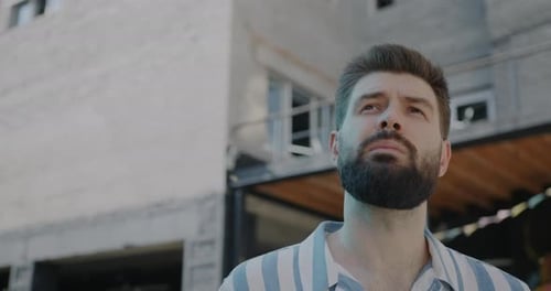 Slow Motion Portrait of Pensive Young Man Looking Around Enjoying Urban View Standing Outdoors in
