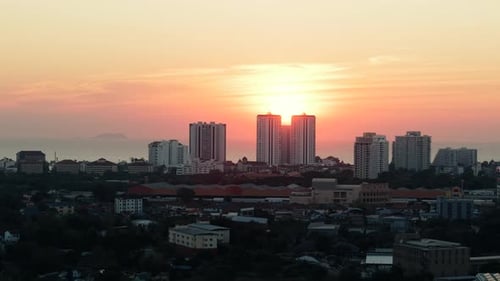 City Skyline at Sunset with a Colorful Sky and the Ocean in the Background