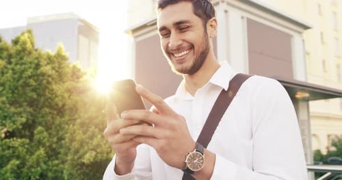 4k video footage of a handsome young businessman using a mobile phone in the city