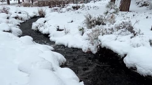 A small stream flowing through the snow in winter