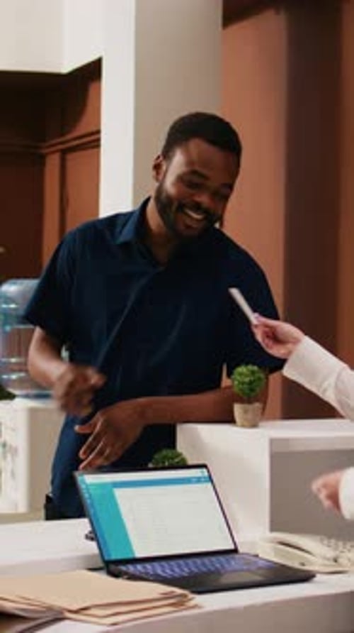 Vídeo vertical: pareja diversa registrándose en el hotel