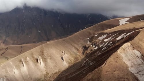 Aerial View of Barren Hilly Landscape and Mountains under Cloudy Sky