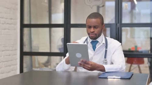 Doctor At Desk Using Tablet in Bright Office