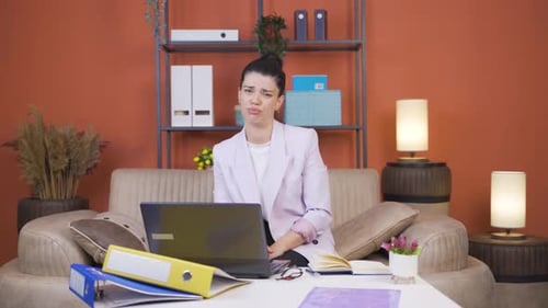 Home office worker young woman looking at camera depressed.