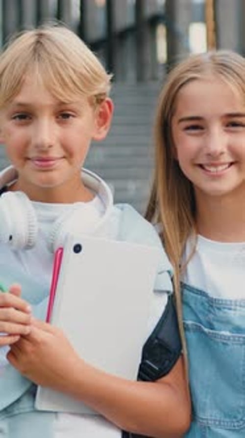 Great Elementary School Happy Boy and Girl Classmates with Books and Backpack Smiling and Looking