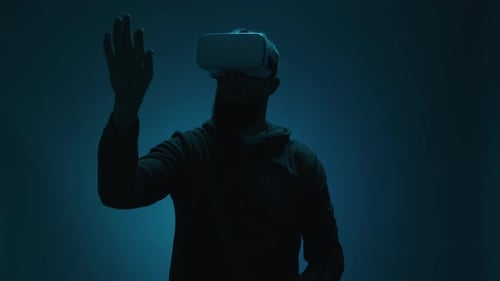 Man Wearing VR Headset Gesturing in the Dark