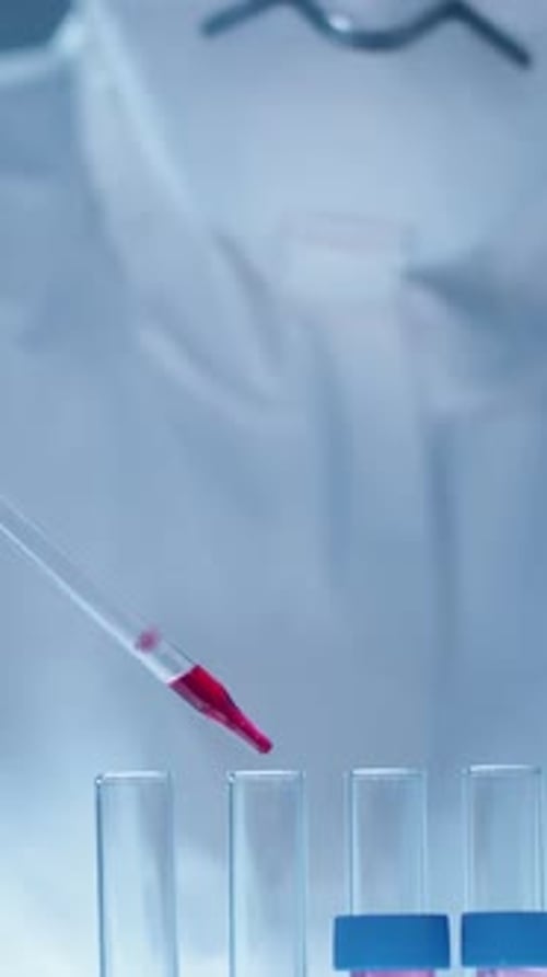 Scientist Uses Pipette to Fill Test Tubes