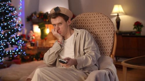 Portrait of Sad Bored LGBT Man Looking at Camera Talking Turning Off TV with Remote Control Sighing