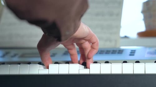 Hand Playing Keyboard Piano at Home