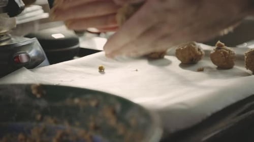 Baker's Hand Rolling Cookie Dough And Putting On Baking Tray. - close up shot