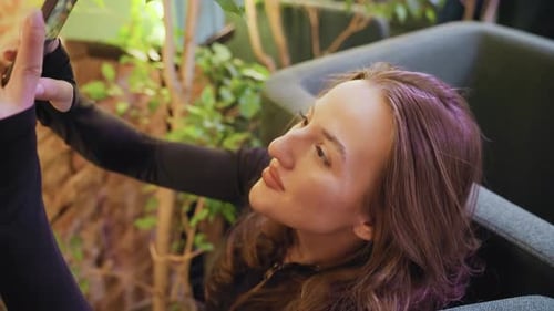 Woman Relaxing Indoors Looking at Her Phone