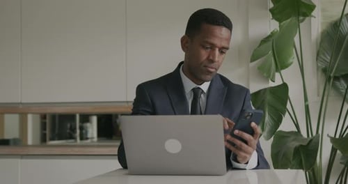 Business executive using Phone and Laptop in Office