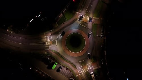 Aerial top down of roundabout lighting at night. Traffic scene in american town. Rising circling sho