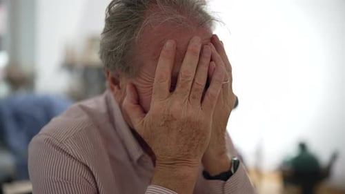 Senior man in despair, displaying a deeply contemplative and concerned expression, indoor setting,