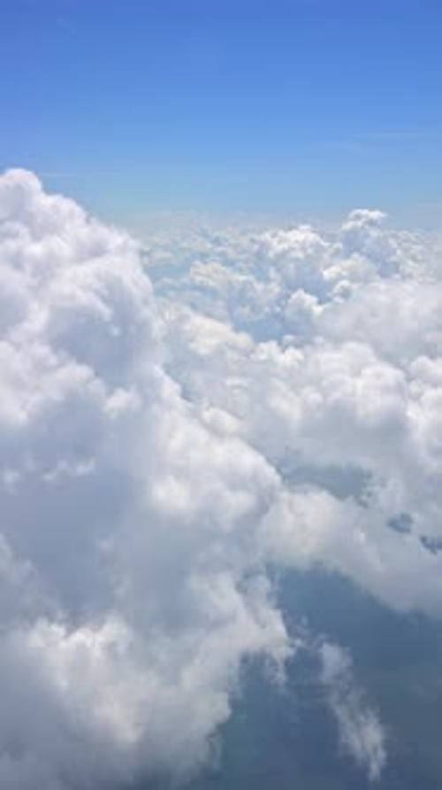 View of the clouds from an airplane window. Vertical