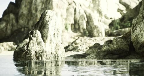 Serene Rocky Landscape By Calm Water Reflecting Sunlight in Nature