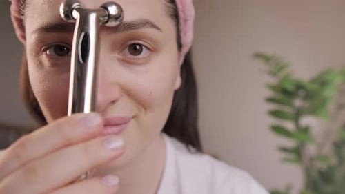 Woman Using Facial Massager for Skin Care Treatment