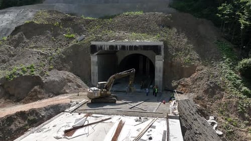 Aerial view of cranes and bridge foundation pillars on construction site of new highway road project