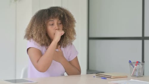 Woman Coughing While Sitting at Her Desk