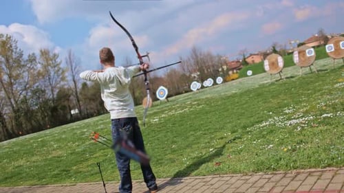Archer draws bow string and shoots arrow