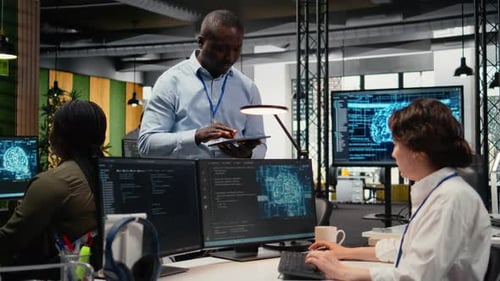 Manager spricht mit Praktikant im Büro unter Verwendung von KI-spezialisierter Hardware