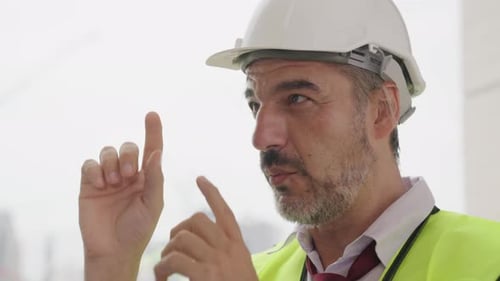 Capataz de engenheiro civil com colete de segurança trabalhando no canteiro de obras