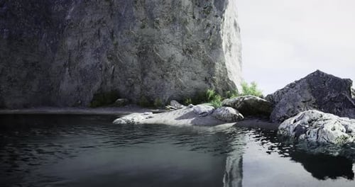 Serene Rocky Shoreline with Calm Waters and Lush Greenery in Daylight