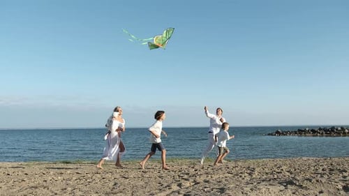 The Family Flies a Kite and Runs Along the Seashore