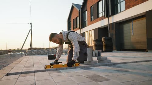 Construction Worker Laying Concrete Paving Slabs