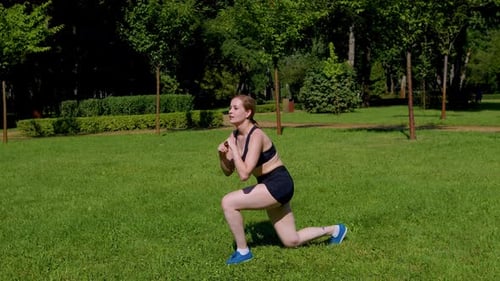 Active Motivated Sporty Fit Woman Performing Jumping Lunges Exercise in Park