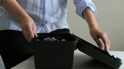 Woman opening toolbox and picking up small spanner