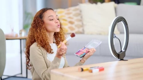 Influenciadora de belleza filmando un tutorial de maquillaje en casa