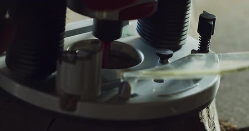 Close up of a carpenter while he is drilling a wooden trunk after he finished to cut it. Concept: