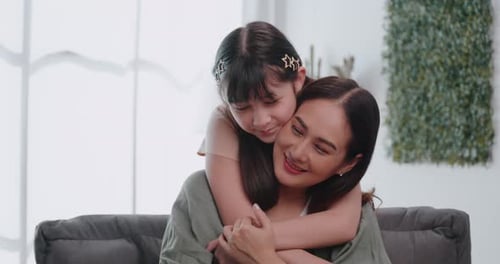 Girl Hugging Mother from Behind on Couch