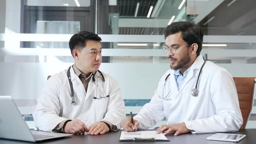 Two doctors collaborating in office, discussing medical strategies and patient care plans during