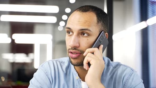 Young Man Talking on Phone in Office