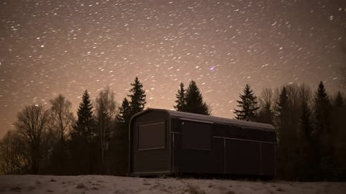 Black Thermowood Cabin Near Coniferous Forest At Night With Stars In The Sky. - timelapse