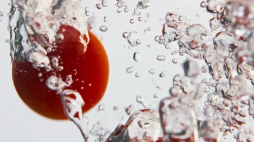 Cherry Tomatoes Splashing into Clear Water